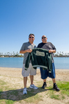 Korner Car Club: Photograph of Korner Car Club members holding a club jacket at Lowrider Council event at Mission Bay