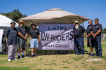 Latin Lowriders Car Club: Photograph of Latin Lowriders Car Club members with banner at Lowrider Council Event at Mission Bay